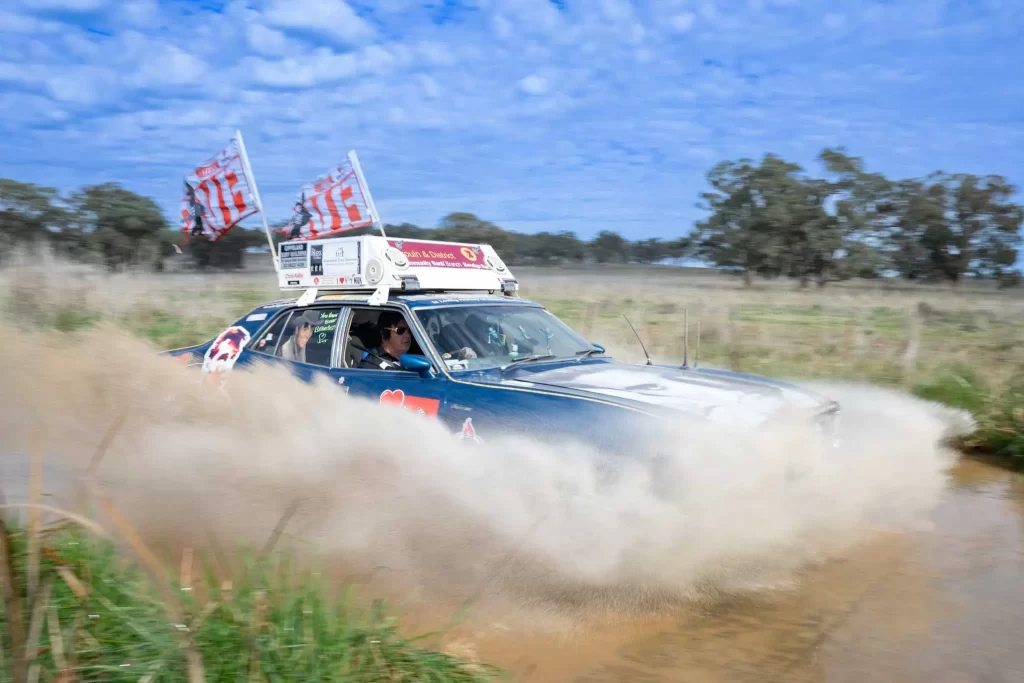 Variety Bash car driving through muddy puddle