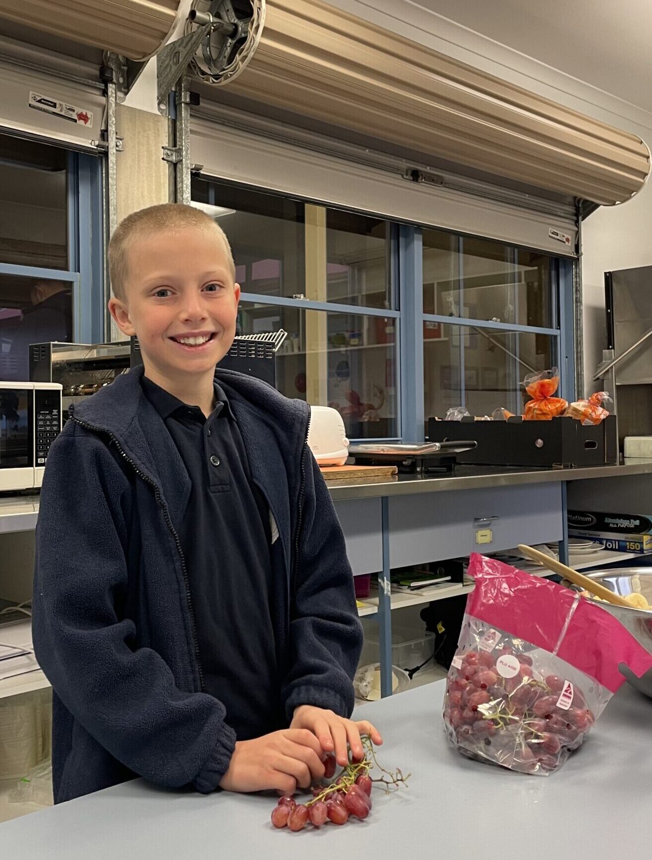 10 year old boy with short cropped blond hair helping to prepare breakfast