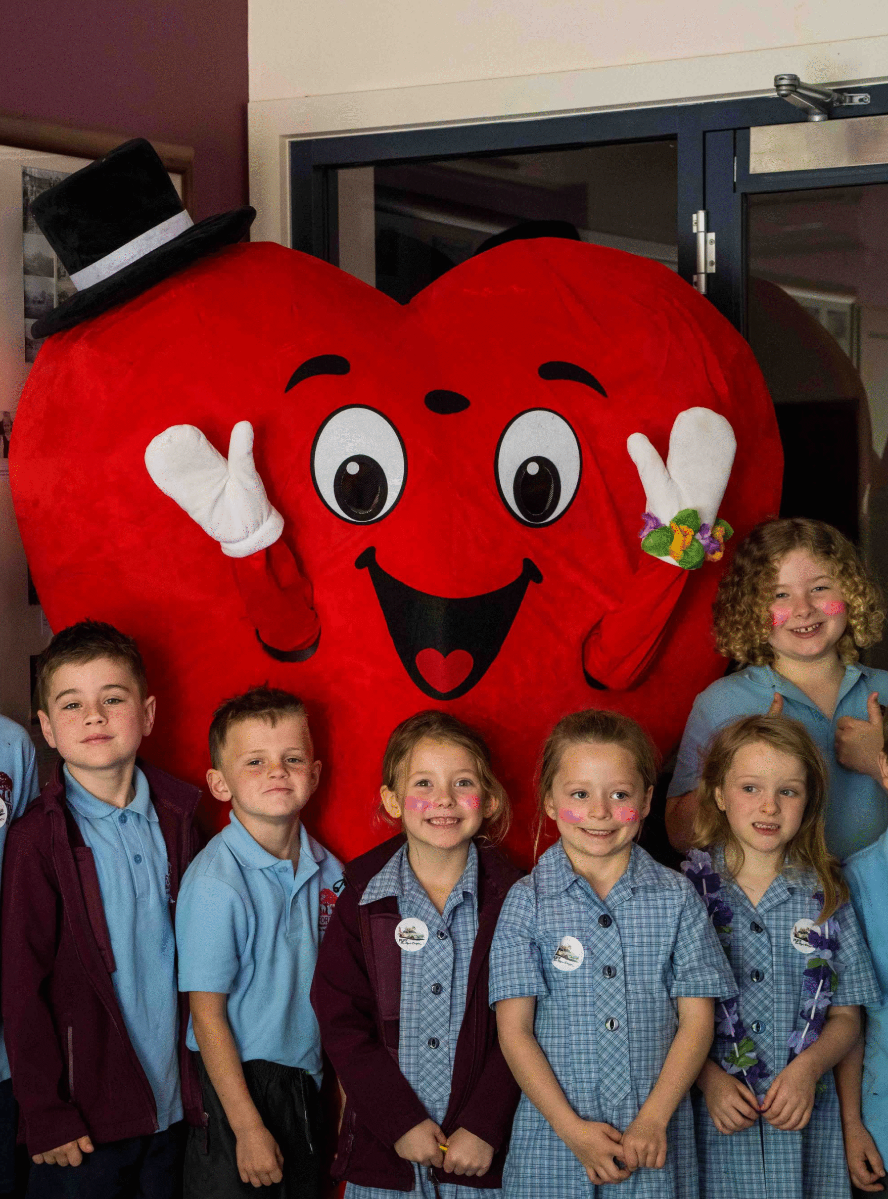 6 kids with face paint in school uniform smiling with hearty